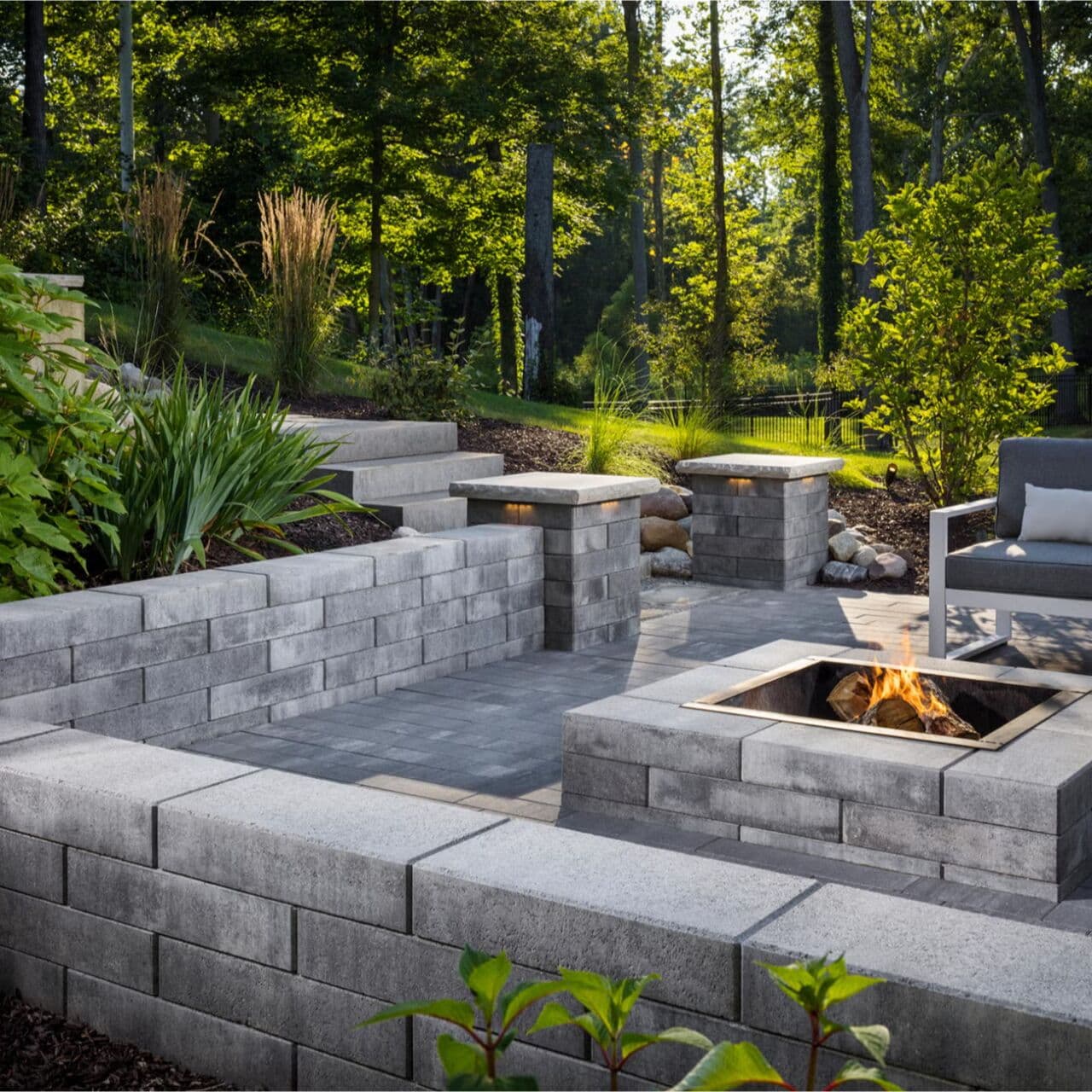 Melville linear garden walls with planted beds, columns and fire pit on a paver patio — Daedalus Contracting, Lower Mainland BC