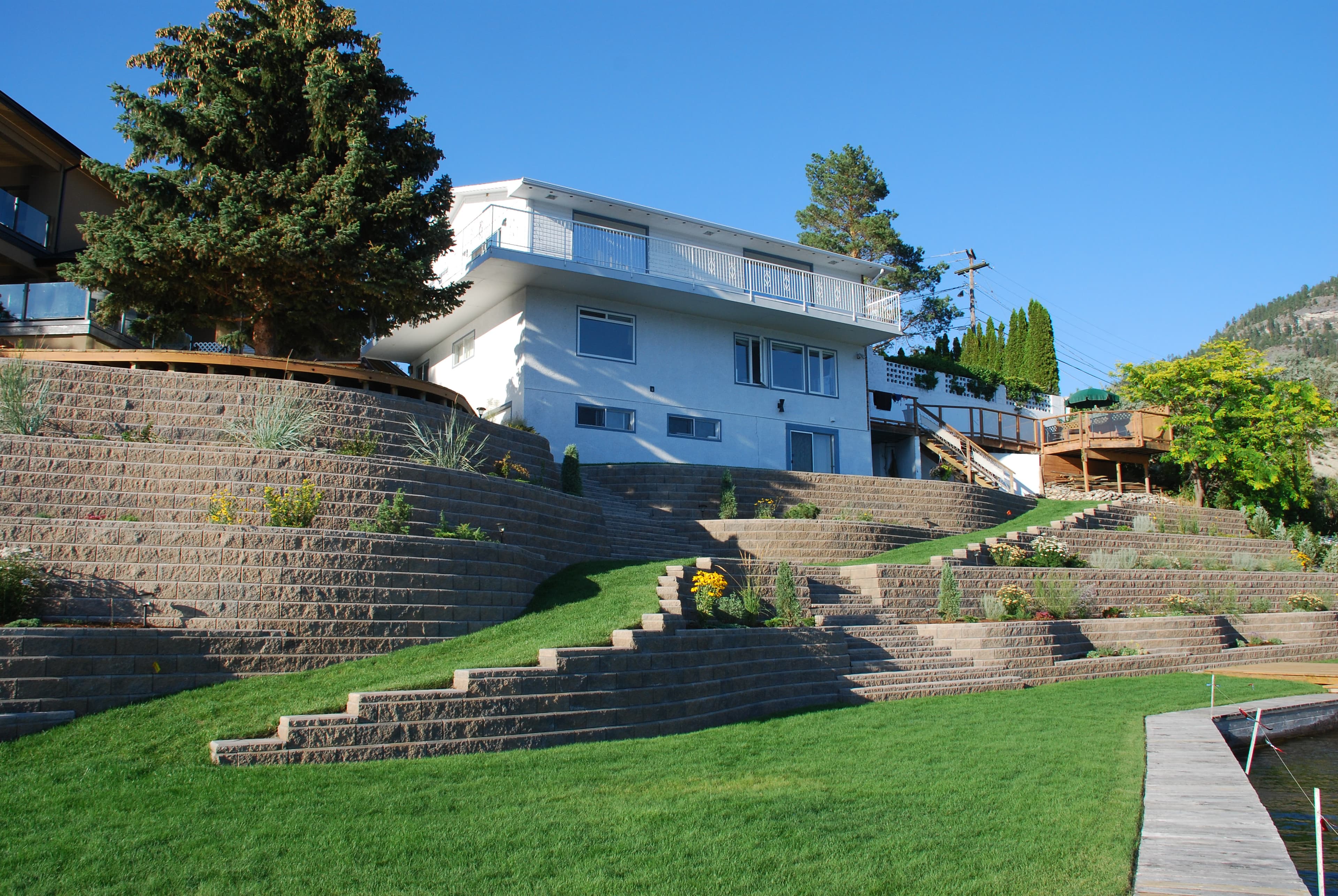 Terraced Allan Block walls with lawns, ramps and stairs transforming a steep waterfront yard — Daedalus Contracting, Lower Mainland BC