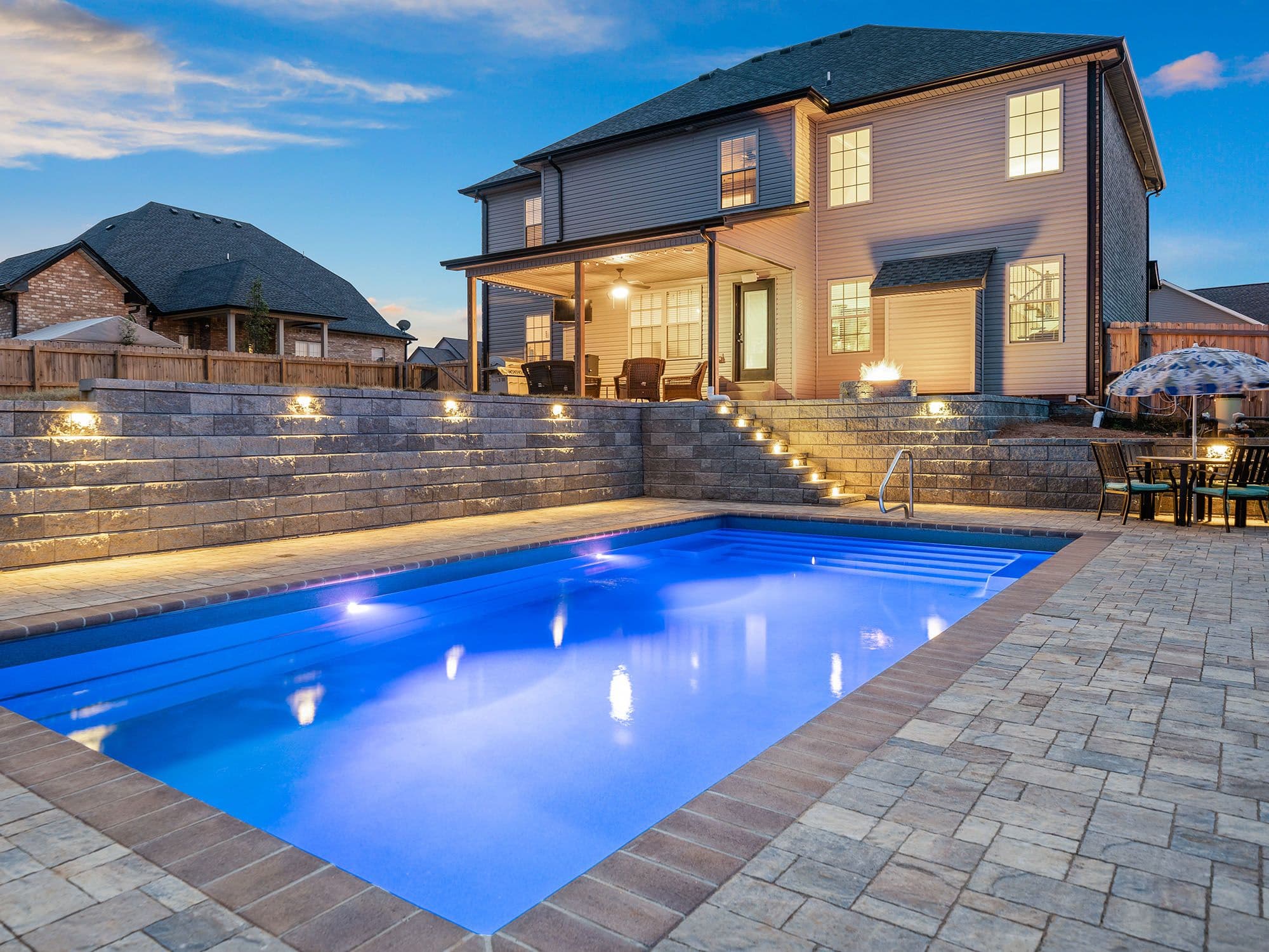 Curved Allan Block terraced retaining walls with stepped stairways below a lakefront home — Daedalus Contracting, Lower Mainland BC